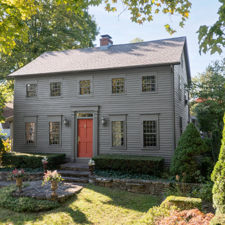 Grey home painted in Benjamin Moore Whale Gray with Iron Ore Red front door using Regal Select Exterior
