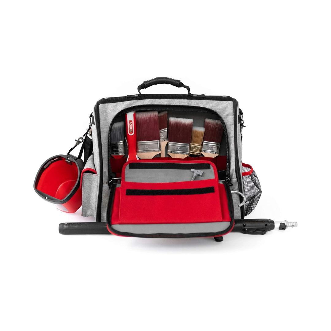 Professional painter carrying Handy Products Deluxe Tool Bag with spray gun and extension pole attached.