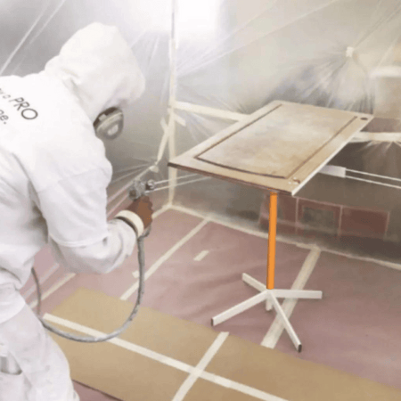 professional painter painting a door on rotating paint stand table